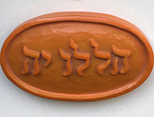 Auf der ovalen Plakette steht das Wort ‚Halleluja‘ in erhabenen hebräischen Buchstaben. 
